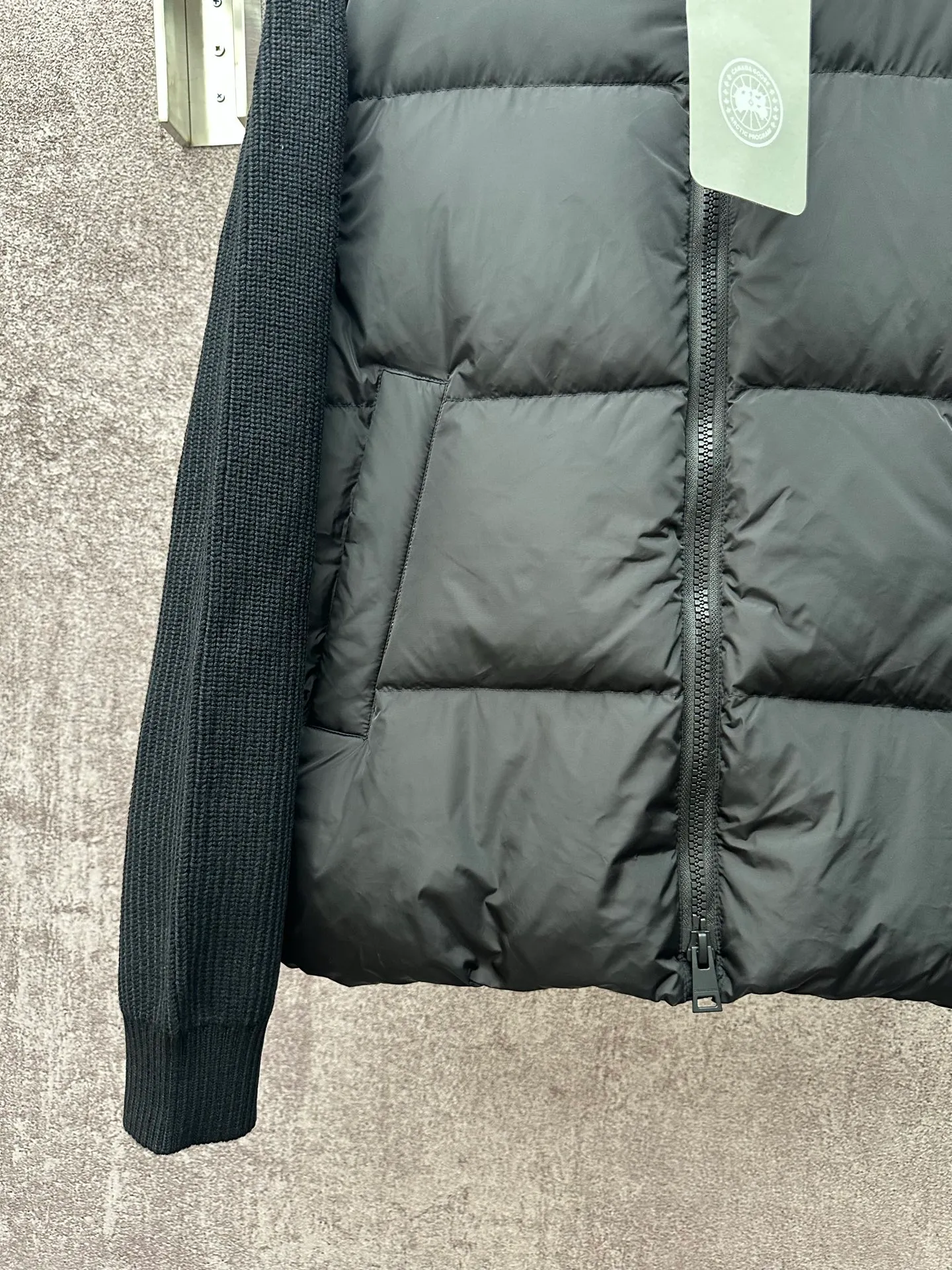 P930 Canada Goose Armband Hooded Down Jacket Fabric selection: The use of high-quality protective nylon fabric not only enhances the wear resistance of the surface, but also takes into account wind resistance, ensuring excellent performance in various harsh weather conditions.  90 national standard high-quality white duck down: selected high-loft down, weighing 170g, light and warm, with excellent temperature locking performance and good resilience.  Three-dimensional quilting process: Precision thread reinforcement to prevent velvet drilling and ensure that the fluffy and resilient elasticity lasts as new.  7-needle medium-thick knitted structure: Use thicker yarns to knit woolen fabrics with obvious thickness and weight. The texture is clearly visible and has a rough, retro texture. It has a good skeleton feel, is relatively stiff, and can maintain the silhouette of clothing for a long time. It also provides more layers of still air to lock in heat.  There is a brand exclusive LOGO on the woolen sleeve arms. It is dark and not obvious in the photo.  Accessories: One-to-one customized logo, one-to-one customized zipper pendant, one-to-one customized snap button SIZE: S M L XL